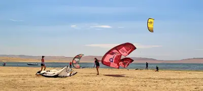 a group of people on a beach flying kites at Bamboo Paracas Hotel in Paracas