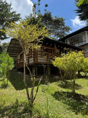 a house with trees in front of it at Cabaña con linda vista en Oxapampa in Oxapampa