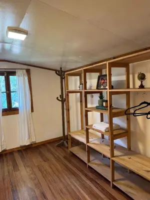 a room with wooden shelves and a window at Cabaña con linda vista en Oxapampa in Oxapampa