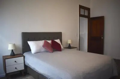 a bedroom with a bed with pillows and two lamps at MirandoelMar - Luna in Lima