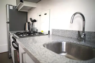 a kitchen with a sink and a stove at MirandoelMar - Luna in Lima