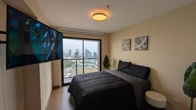 a bedroom with a bed and a flat screen tv at Descanso en Oscuridad Absoluta in Lima