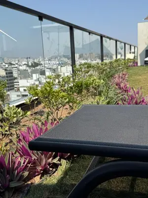 a black bench sitting on top of a hill with flowers at Miraflores La Mar in Lima