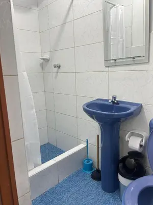 a bathroom with a blue sink and a shower at Departamentos Sumaq Plaza II in Ayacucho