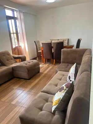 a living room with two couches and a table at Departamentos Sumaq Plaza II in Ayacucho
