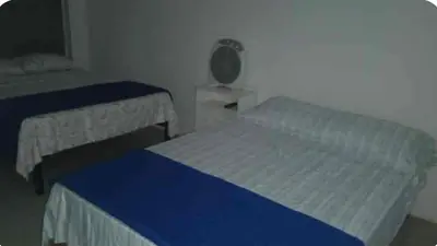 a small bedroom with two beds and a fan at Casa En Asia in San Antonio