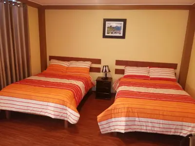 two beds sitting next to each other in a bedroom at Nasca Travel One Hostel in Nazca