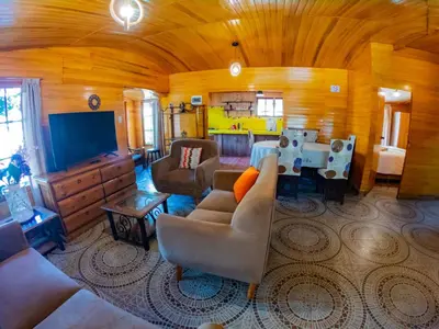 a living room with a couch and a tv at Kay Pacha Wellness Place Eco in Ayacucho