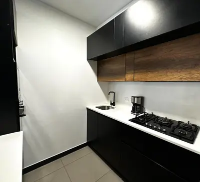 a small kitchen with black cabinets and a sink at 2 Bedroom Apartments San Isidro Business Zone in Lima