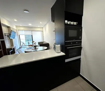 a kitchen with a counter and a sink and a microwave at 2 Bedroom Apartments San Isidro Business Zone in Lima