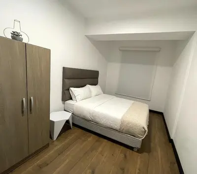a small bedroom with a bed and a cabinet at 2 Bedroom Apartments San Isidro Business Zone in Lima