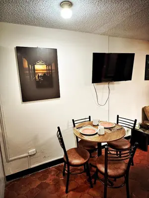 a dining room with a table and chairs and a tv at Mini Apartamento BARRANCO in Lima