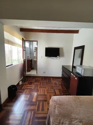 a bedroom with a bed and a television on the wall at Amplia habitación independiente Larcomar in Lima
