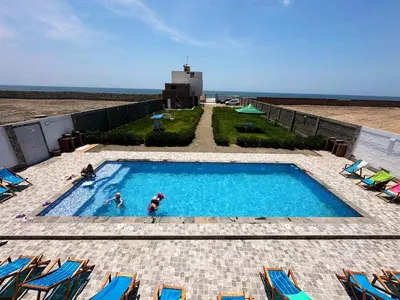 a swimming pool with two people in the water at RELAX Y PISCINA con vista al MAR - DUPLEX in Cerro Azul