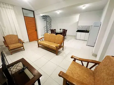 a living room with a couch and chairs and a kitchen at RELAX Y PISCINA con vista al MAR - DUPLEX in Cerro Azul