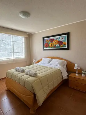 a bedroom with a large bed with a painting on the wall at Casita en Ica con piscina in Ica