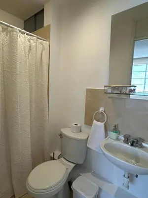 a white bathroom with a toilet and a sink at Casita en Ica con piscina in Ica