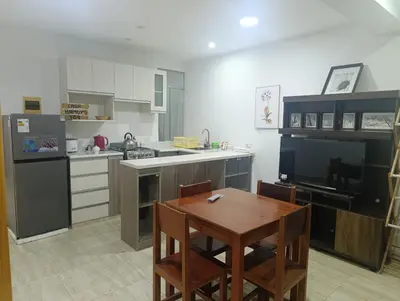 a kitchen with a wooden table and a table and chairs at Casa Hamuys - Ica in Ica