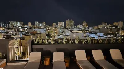 a balcony with a view of a city at night at Beautiful Duplex in the Heart of Miraflores in Lima