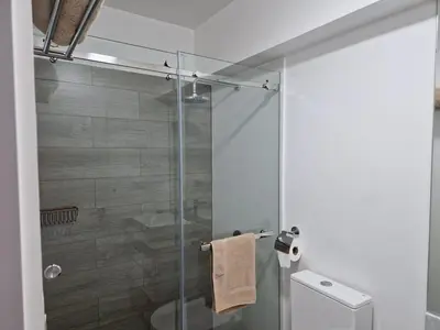a bathroom with a glass shower with a toilet at Beautiful Duplex in the Heart of Miraflores in Lima