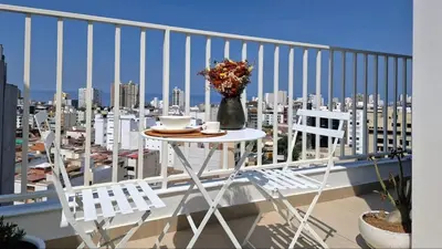 a table and chairs on a balcony with a view of a city at Beautiful Duplex in the Heart of Miraflores in Lima