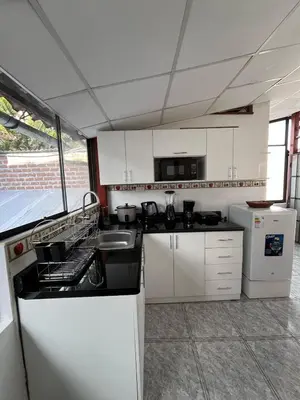 a small kitchen with white cabinets and a sink at Allyu Wasi-Chanka in Andahuaylas