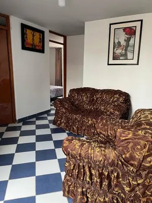 a living room with a couch and a checkered floor at Allyu Wasi-Chanka in Andahuaylas