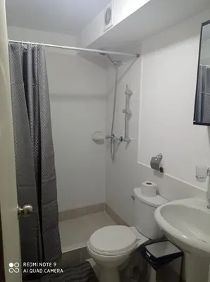 a bathroom with a toilet and a sink and a shower at Cozy Furnished Brand New Apartment