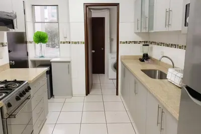 a kitchen with white cabinets and a sink at Bella vista al mar y Larcomar - Miraflores in Lima