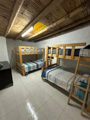 a room with two bunk beds and a table at Casa de campo relax y piscina in Cerro Azul