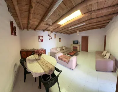 a living room with a table and a couch at Casa de campo relax y piscina in Cerro Azul