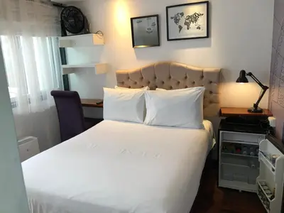 a bedroom with a large bed with a white bedspread at La Casa del Viajero in Lima