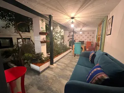 a living room with a blue couch and some plants at La Casa del Viajero in Lima
