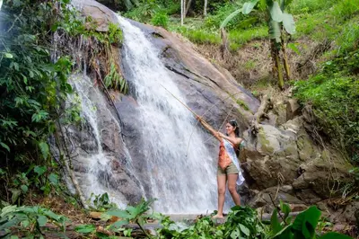 a woman standing in front of a waterfall at Hospedaje EL EDEN DE DON AYDEN in Satipo