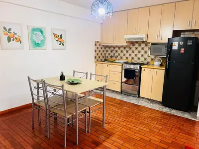 a kitchen with a table and chairs and a refrigerator at Monterrico Polo Aparts 6 - DPTO CON 3 CAMAS FRENTE EMBAJADA USA in Lima