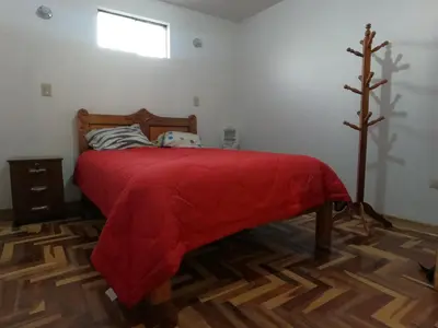 a bedroom with a bed with a red blanket on it at Mirador Ernesto Gunter in Cusco