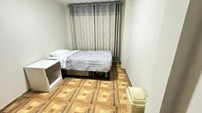 a small bedroom with a small bed and a wooden floor at Habitación privada a 20 min del aeropuerto de Lima in Lima