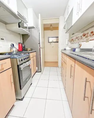 a kitchen with white tile flooring and a stove at Hermoso apartamento cerca al estadio San Marcos y el Aeropuerto in Lima