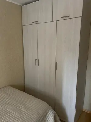 a bedroom with white cabinets and a bed at Hermoso apartamento cerca al estadio San Marcos y el Aeropuerto in Lima