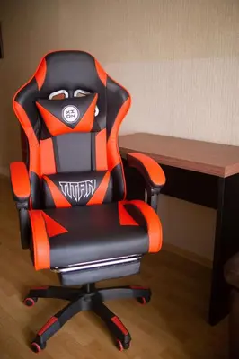 an orange and black office chair sitting next to a desk at Hermoso apartamento cerca al estadio San Marcos y el Aeropuerto in Lima