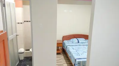 a small bedroom with a bed and a bathroom at Hospedaje El Sureño in Satipo