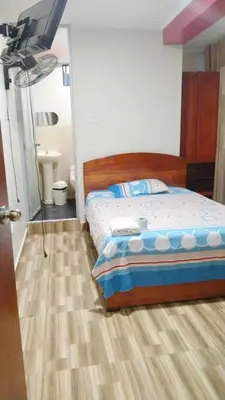 a bedroom with a bed and a flat screen tv at Hospedaje El Sureño in Satipo
