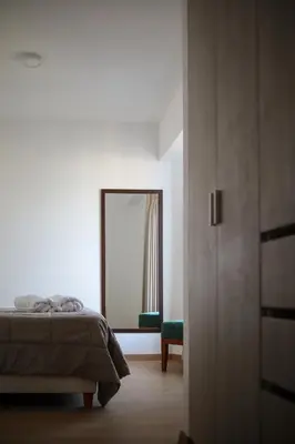 a bedroom with a bed and a mirror and a window at Brand new apartment in Olivar of San Felipe in Lima