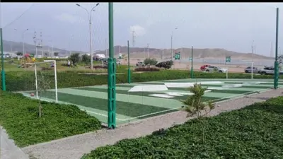 a basketball court with green poles and grass at Alojate en Mala casa del valle in Mala