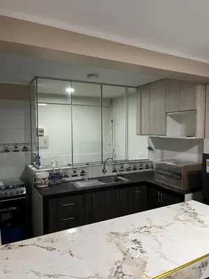 a kitchen with wooden cabinets and a marble counter top at Departamento cómodo para una estancia feliz in Ayacucho
