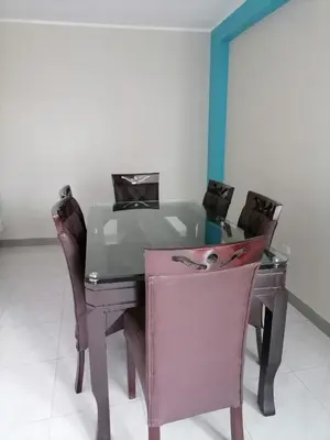 a dining room table with chairs and a pink desk at Departamento cómodo para una estancia feliz in Ayacucho
