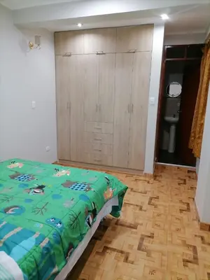 a bedroom with a bed and a large cabinet at Departamento cómodo para una estancia feliz in Ayacucho
