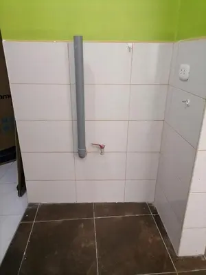 a bathroom with a pipe on a tiled wall at Departamento cómodo para una estancia feliz in Ayacucho