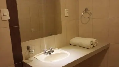 a bathroom with a sink and a mirror and a towel at Belle Sand Hotel in Ica