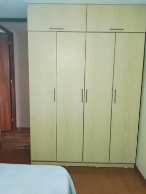 a bedroom with white cabinets and a bed at Adriana in Lima